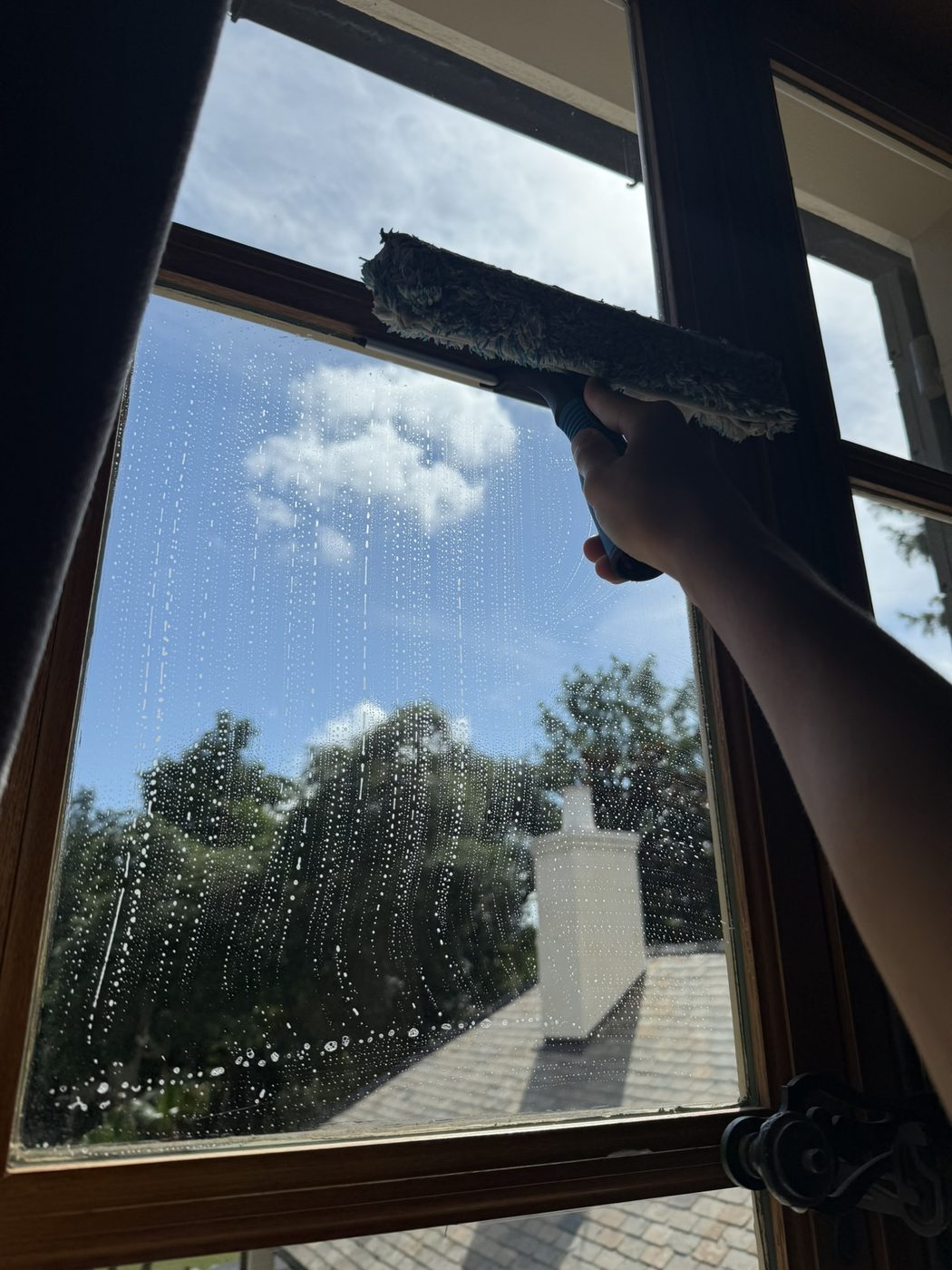 Hand-squeegeeing an interior windowpane to a streak-free finish